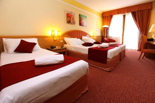a hotel room with two beds and a desk at Villa Fiorita in Monastier di Treviso