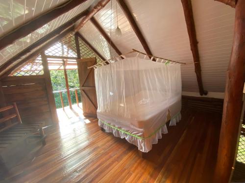 an attic room with a bed with a net at Eco Guest House- Sarapiquí 2 in Sarapiquí