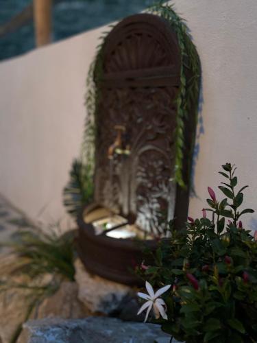 a small shrine sitting on a rock next to a plant at Finca Las Fuentezuelas in Carataunas