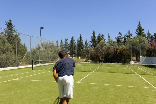 two people playing tennis on a tennis court at Porto Angeli in Archangelos