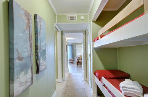 a small room with a bunk bed and a hallway at Nothing But Ocean in Forest Beach in Hilton Head Island