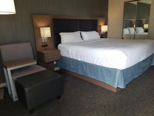 a hotel room with a large bed and a chair at Holiday Inn Express Edmonton Downtown by IHG in Edmonton