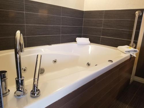 a bathroom with a tub, sink, and mirror at Holiday Inn Express Edmonton Downtown, an IHG Hotel in Edmonton