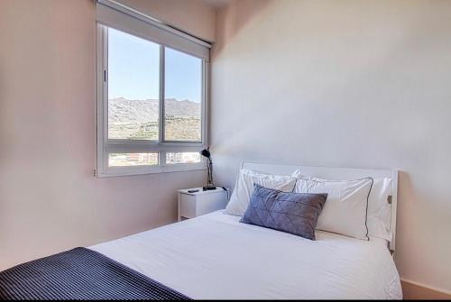 a bedroom with a white bed with a window at Laureli in Tazacorte