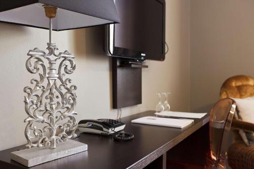 a desk with a computer and a lamp on it at Saga Hotel Oslo, WorldHotels Crafted in Oslo