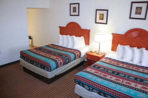 Säng eller sängar i ett rum på The Classic Desert Aire Hotel
