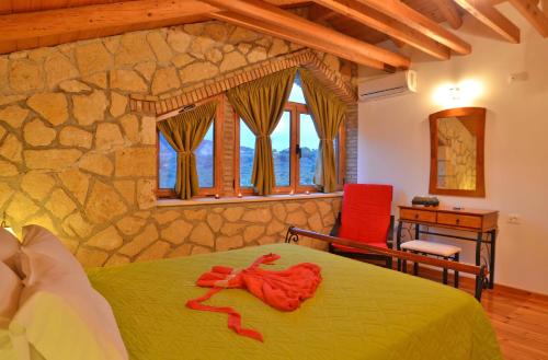 a bedroom with a green bed and a stone wall at Villa Tireda in Keri