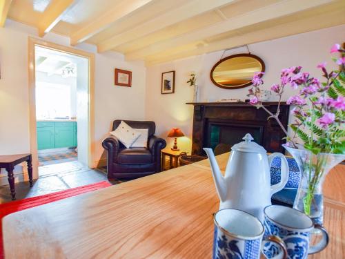 a living room with a table with a vase of flowers at Ty Gwyn in Goodwick