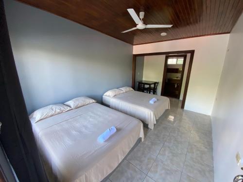 a bedroom with two beds and a ceiling fan at Hotel Puerto San Luis in Tilarán