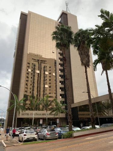 a large building with cars parked in a parking lot at Localização incrível vista ótima equipado e novo in Brasília