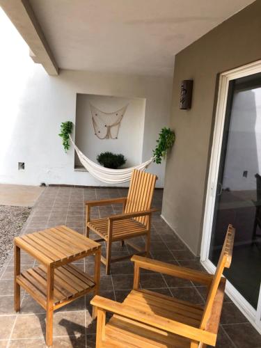 a porch with two chairs and a table and a hammock at Caracoles Homes in Puerto Peñasco