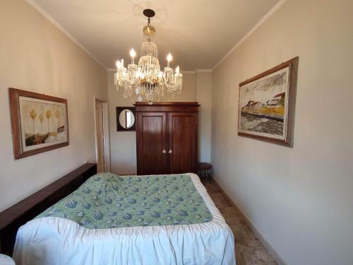 een slaapkamer met een bed en een kroonluchter bij Intero Appartamento a soli 50 m dal mare in Viareggio