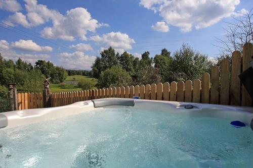 un bain à remous en face d'une clôture en bois dans l'établissement Rowan Cottage, à Aviemore
