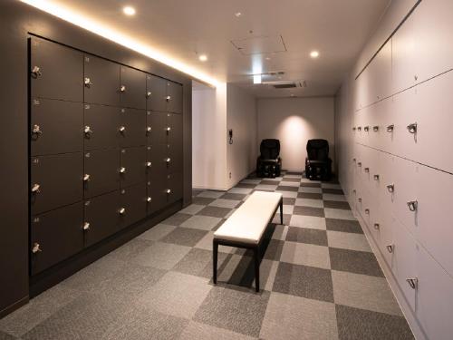 a locker room with lockers and a bench in it at Hotel Intergate Osaka Umeda in Osaka