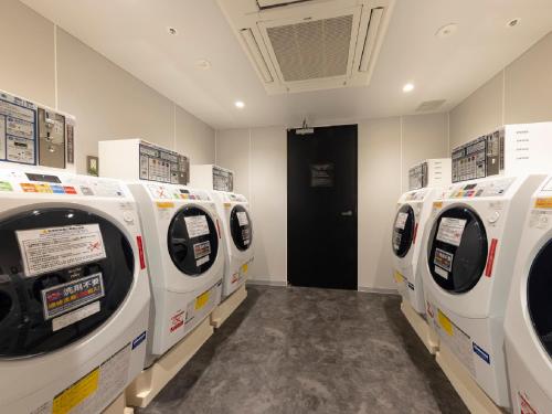 a row of white washing machines in a room at Hotel Intergate Osaka Umeda in Osaka