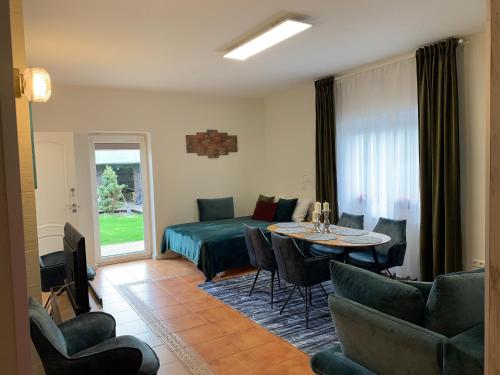 a living room with a bed and a table and chairs at Vila Renata Laure in Palanga