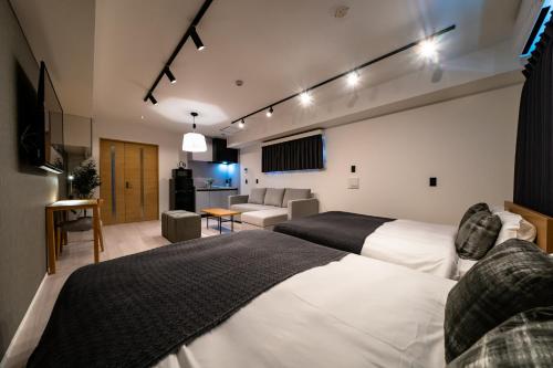 een hotelkamer met twee bedden en een woonkamer bij STAY IN YEBISU in Osaka
