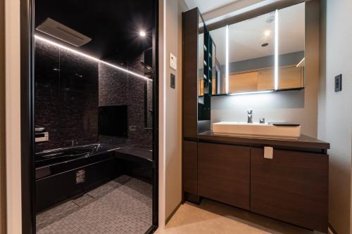 een badkamer met een wastafel en een spiegel bij STAY IN YEBISU in Osaka