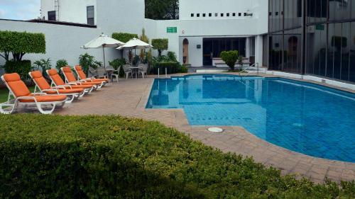 a swimming pool with lounge chairs and a swimming pool at Holiday Inn Morelia by IHG in Morelia
