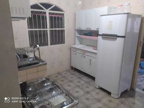 a kitchen with a white refrigerator and a stove at Casa 3 quartos com Piscina em Itatiaia in Itatiaia