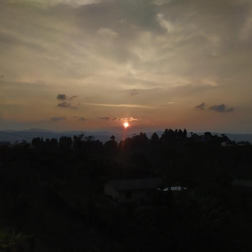 a sunset with the sun setting in the distance at Guané Glamping Ecolodge Jacuzzi Privado Oriente Antioqueño in Guarne