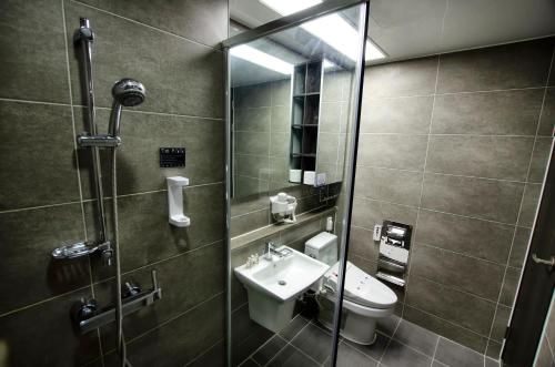 a bathroom with a toilet and a sink and a shower at Hotel Bellia in Busan