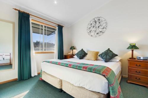a bedroom with a bed and a window at Cottages on Lovedale - Cottage No. 3 in Lovedale