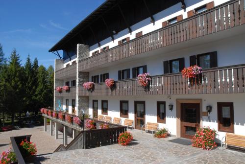 un bâtiment avec des fleurs sur ses balcons dans l'établissement Casa Santa Maria, à Folgaria