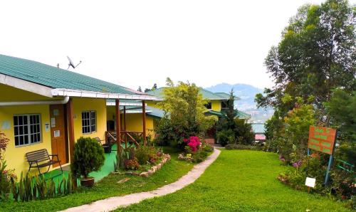 a yellow house with a garden in front of it at Soboroong Farmer's Cottage in Kundasang