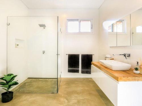a bathroom with a glass shower and a sink at Amaroo in Bowral