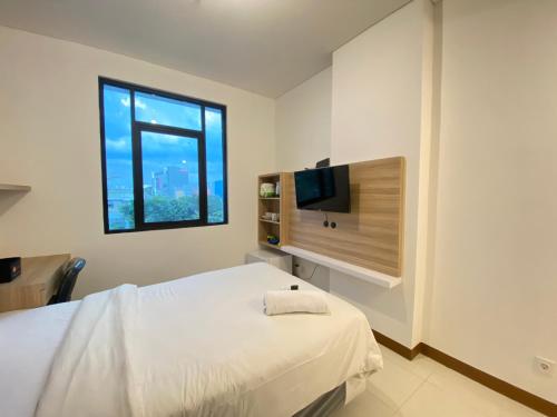 Ένα ή περισσότερα κρεβάτια σε δωμάτιο στο Simply Studio Room Semi Apartment at The Lodge Paskal near BINUS University By Travelio
