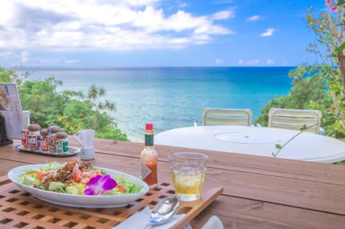 a table with a bowl of salad and a drink at Seven Colors Ishigakijima in Ishigaki Island