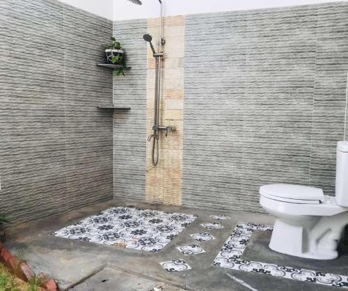 a bathroom with a shower with a toilet and a rug at Casa Vi Mia in Ấp Thiện Sơn
