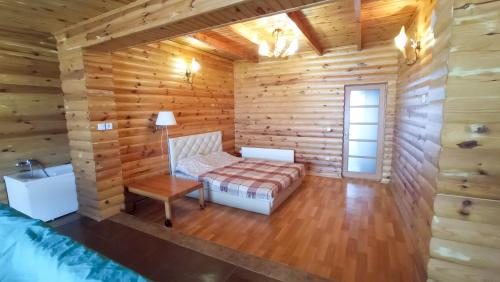 Una habitación en una cabaña de troncos con una cama y una mesa. en Дача у моря, en Odessa