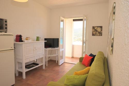 ein Wohnzimmer mit einer grünen Couch mit bunten Kissen in der Unterkunft Villa Manzoni in Campese