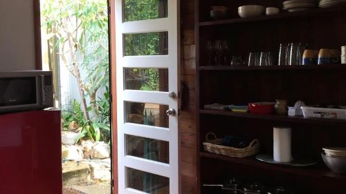 eine Tür zu einer Küche mit Gartenblick in der Unterkunft Potters Cottage in Bellingen