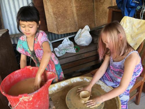 Deux jeunes filles jouent avec une roue de poterie dans l'établissement Potters Cottage, à Bellingen
