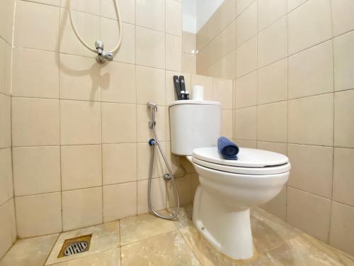 a bathroom with a toilet with a hose at Comfy & Well Appointed 2BR at Tamansari Panoramic Apartment By Travelio in Bandung