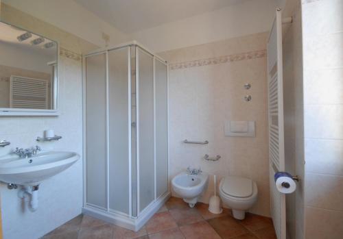 a bathroom with a shower and a toilet and a sink at Casa Santa Maria in Folgaria
