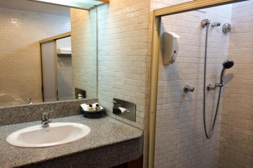 a bathroom with a sink and a shower at Sirin Hotel Hua Hin in Hua Hin