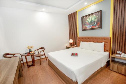 a hotel room with a bed and a table at MOMALI Hotel Ninh Binh in Ninh Binh