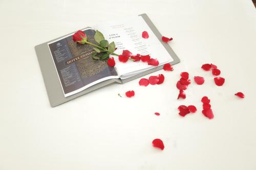 a book with roses and petals on a table at MOMALI Hotel Ninh Binh in Ninh Binh