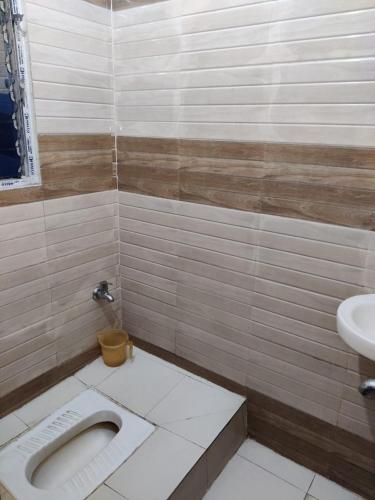 a bathroom with a toilet and a sink at HOTEL SUKHMANI in Guwahati