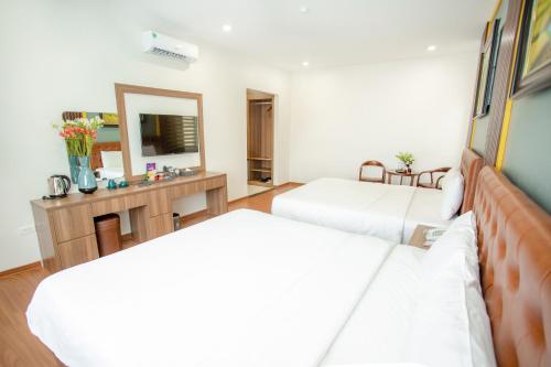 a hotel room with two beds and a mirror at MOMALI Hotel Ninh Binh in Ninh Binh