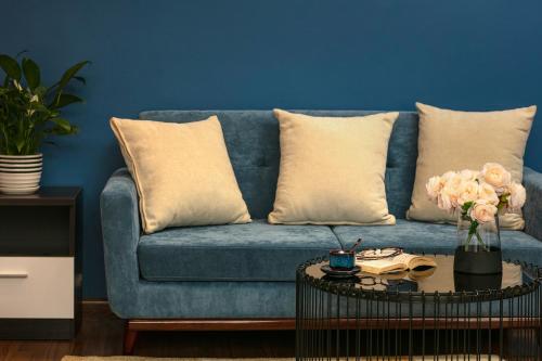 a blue couch with pillows and a table with flowers at Hanoi 20 Hotel & Apartment in Hanoi