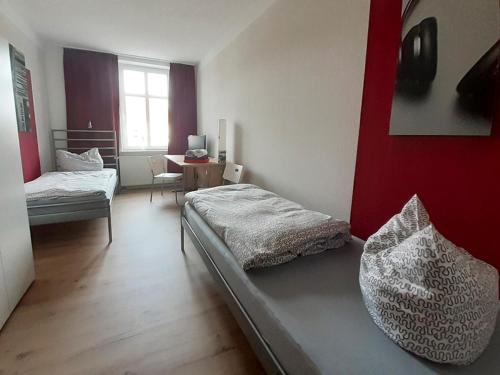 ein Schlafzimmer mit einem Bett und einem Tisch mit einem Fenster in der Unterkunft Pension BERLIN in Spremberg in Spremberg
