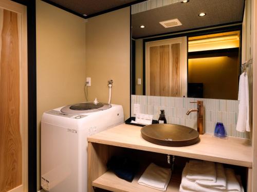 a bathroom with a washing machine and a sink at Kanade Fushimiinari-Taishame in Kyoto