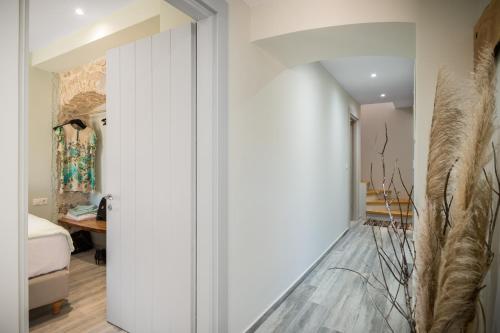 a hallway with white walls and a room with a bed at Amelia & Nicholas Stone Houses in Doukádes
