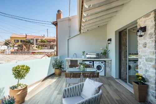 a patio with a table and chairs on a balcony at Amelia & Nicholas Stone Houses in Doukádes