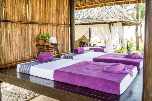 a group of three beds in a room at Pandanus Resort in Mui Ne